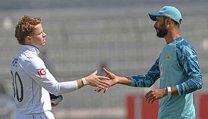 England’s captain Ollie Pope shakes hands with his Pakistan’s counterpart Shan Masood (R) at the end of the first Test cricket match at the Multan Cricket Stadium in Multan on October 11, 2024. — AFP