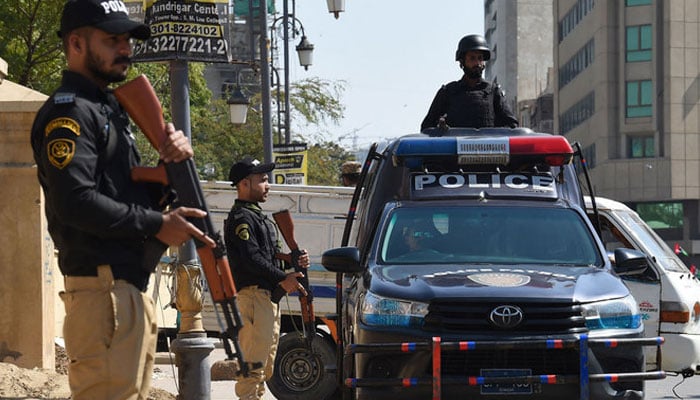 Policemen stand guard outside a polling station during the nationwide general elections in Karachi on February 8, 2024. — AFP