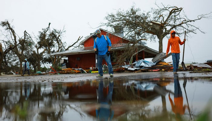 Residents help to clean up debris in aftermath of Hurricane Milton, in Lakewood Park, near Fort Pierce, in St Lucie County, Florida, US on October 11, 2024. — Reuters