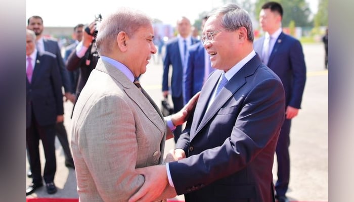 Prime Minister Shehbaz Sharif (left) welcomes Chinese Premier Li Qiang as he arrives at Nur Khan Airbase in Rawalpindi, on October 14, 2024. — PMO