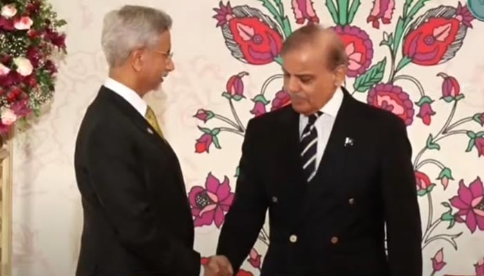 Prime Minister Shehbaz Sharif (right) shake hands with Indian foreign minister Subrahmanyam Jaishankar at dinner for SCO leaders. — Screengrab via Geo News