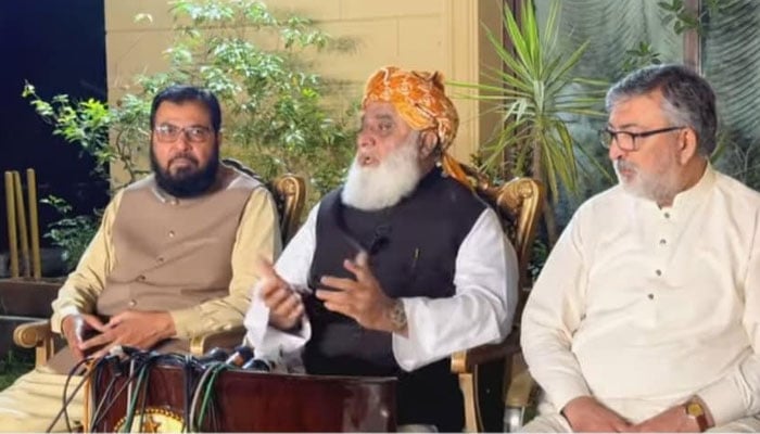 The image shows the JUI-F spokesman Aslam Ghari (left) and Senator Kamran Murtaza (right) sitting along with party chief Maulana Fazlur Rehman. — Facebook/Aslam.Ghauri.JUI