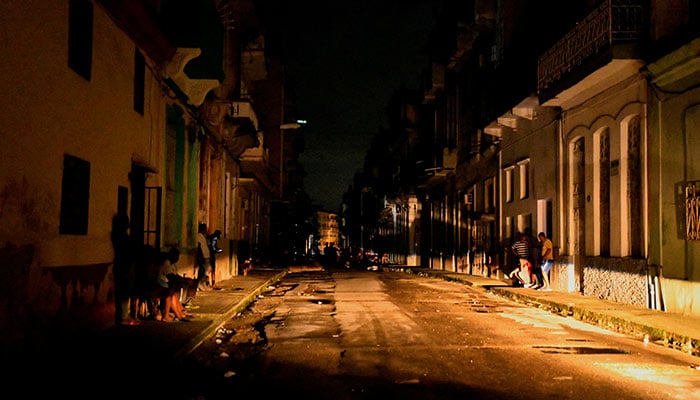 People gather in the street at night as Cuba is hit by an island-wide blackout, in Havana, Cuba, October 18, 2024. — AFP