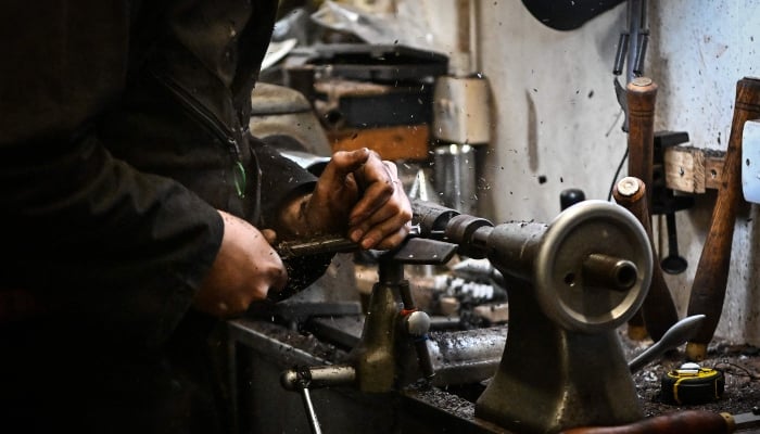 Ruari Black, the last traditional bagpipe-makers who make everything by hand from start to finish, makes a bagpipe chanter in the workshop of Kilberry Bagpipes in Edinburgh, on October 7, 2024. — AFP