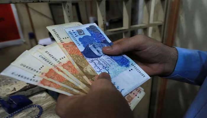 A man counts Pakistani rupee notes at a currency exchange shop in Peshawar, Pakistan September 12, 2023. — Reuters