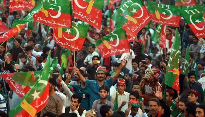 PTI supporters and workers hold flags in a rally. - AFP/Archive