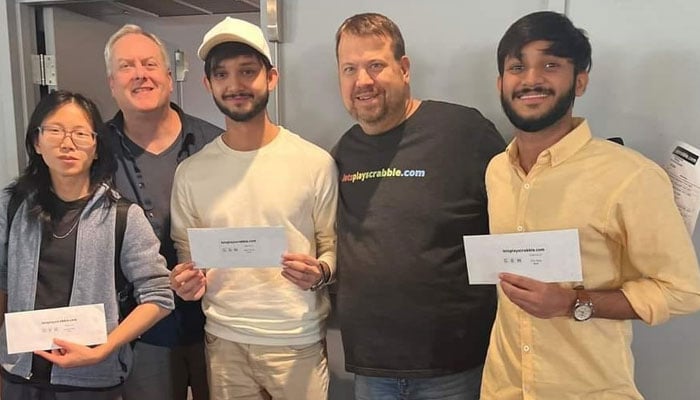 Pakistans Sohaib Sanaullah (right in yellow shirt) poses for a photo after winning the B Division of the Lake George Scrabble Tournament in New York. — Reporter