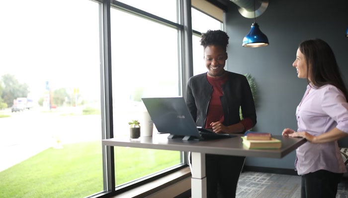 A representational image shows two women standing at a supposed workplace. — Unsplash/File