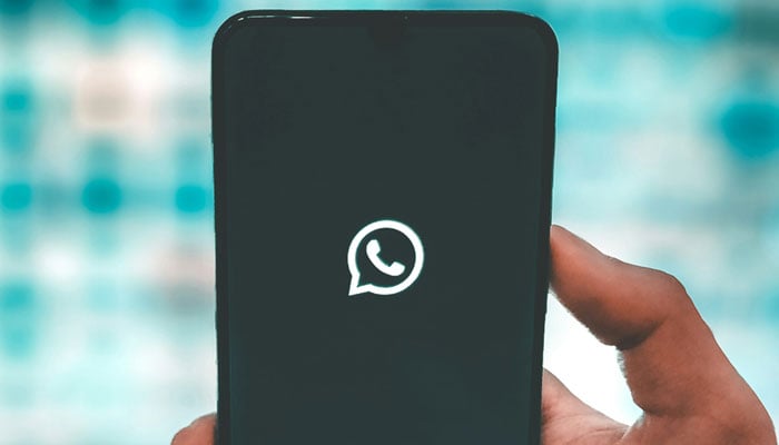 A representational image showing the WhatsApp logo displayed on a phone screen. — Unsplash