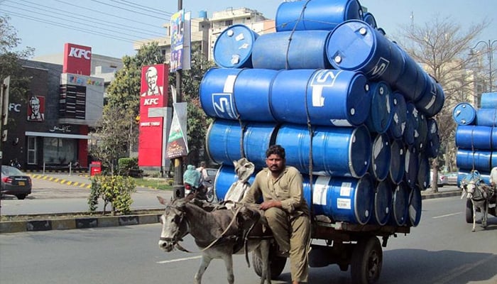 A donkey cart holder on the way while loaded with empty drums in Faisalabad. — APP/File