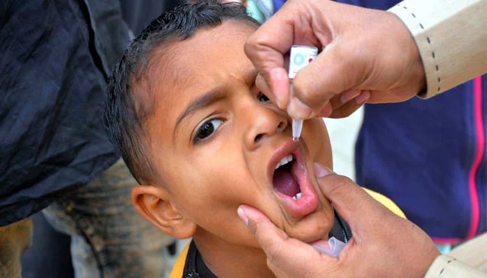 A health worker administrates polio-vaccine drops to a child during anti-polio immunisation campaign, in Hyderabad on February 26, 2024. — APP