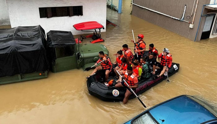 Philippine Coast Guard personnel evacuate residents after flood waters rose due to heavy rains brought by Tropical Storm Trami in Camarines Sur, Philippines on October 24, 2024. — Reuters