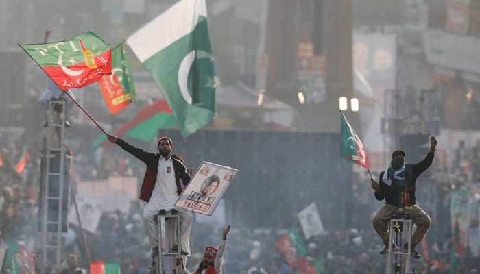 Supporters of PTI sit on scaffoldings to see their leader Imran Khan in his first public appearance since a gun attack on him in 2022. —Reuters