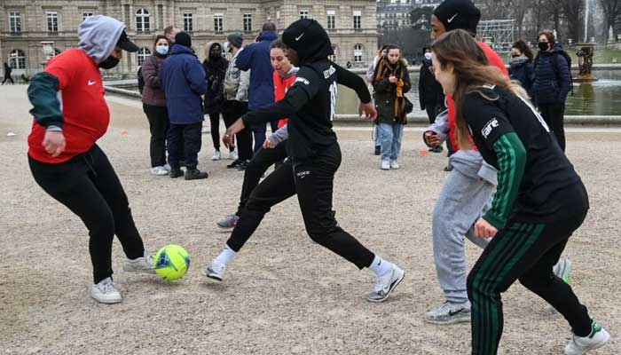 A group of women calling themselves Les Hijabeuses play football in the Luxembourg garden facing the French Senate in Paris on 26 January 2022 in protest of a ban. — AFP