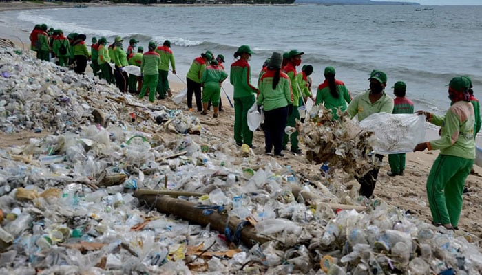 Workers collect plastic waste as they clean up Kuta beach near Denpasar on Indonesia’s tourist island of Bali, Indonesia. — AFP/File