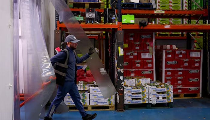 A worker moves pallets of fruit during early morning business hours at New Covent Garden Market in London, Britain, October 8, 2024. — Reuters