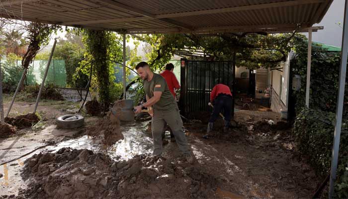 People remove the mud of a house after heavy rains and floods in Alora, Spain on October 29, 2024. — Reuters