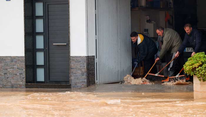 People remove water from a residence after the Spanish meteorological agency put the Valencia region in the highest red alert for extreme rainfalls, in Llombai, Valencia, Spain on October 29, 2024. — Reuters