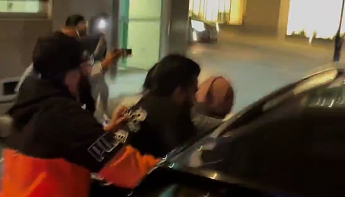 PTI protesters attempt to stop ex-CJP Qazi Faezs vehicle in London. — Screengrab/X/@MurtazaViews