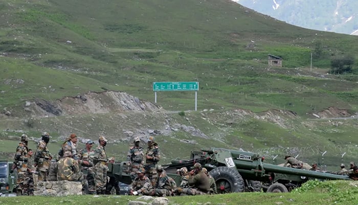 Indian army soldiers rest next to artillery guns at a makeshift transit camp before heading to Ladakh, near Baltal, southeast of Srinagar. — Reuters/File