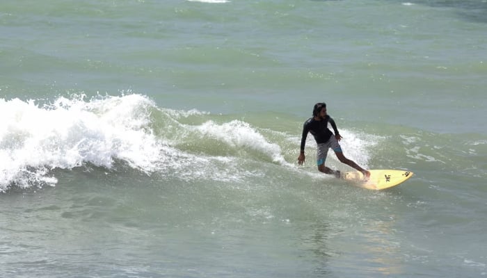 Mujahid rides a wave at the end of surfing season, at the Turtle Beach in Karachi on September 4, 2024. —Reuters