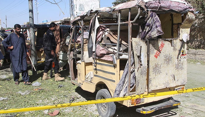 A member of the bomb disposal squad and a police officer survey the crime scene after a blast in Mastung on November 1, 2024. — Reuters