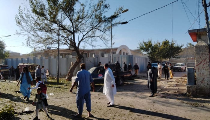 Locals gather around the damaged police vehicle at the site of the blast. — Photo by reporter