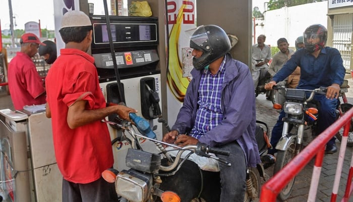 An employee of a gas station fills the tank of a motorbike in Karachi on July 16, 2021. —AFP