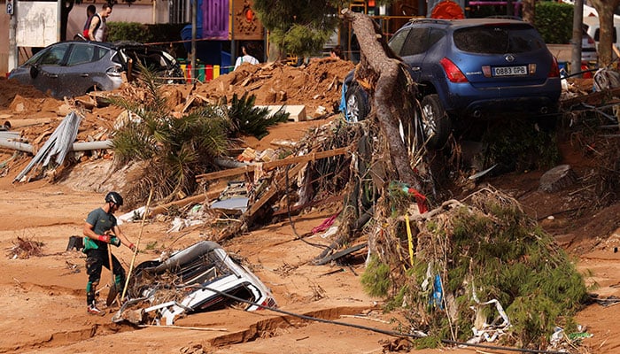 A man stands near damaged vehicles following heavy rains that caused floods, in Paiporta, near Valencia, Spain, November 1, 2024. — Reuters