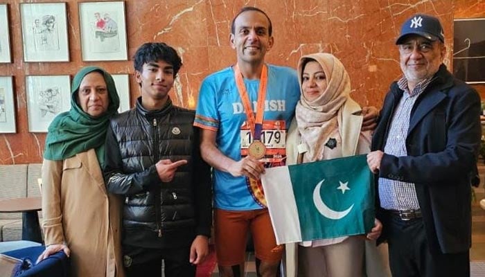 Pakistani runner Danish Elahi poses with his family while holding a Pakistani flag after the New York City Marathon in New York, US, on November 3, 2024. — Supplied