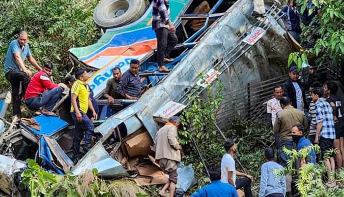 This handout photograph shows people at the site of a bus accident after it fell into a gorge at Almora district in Indias Uttarakhand state on November 4, 2024. — Reuters