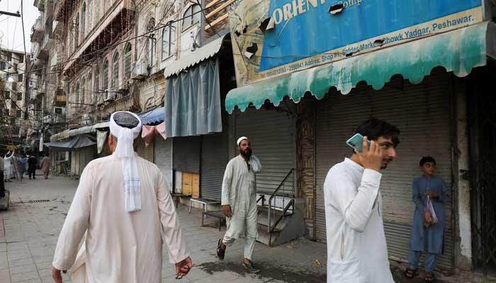 People walk along closed foreign exchange shops, in Peshawar on September 7, 2023. — Reuters