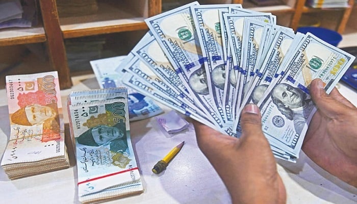 A money dealer counts US dollars at  currency exchange. — AFP/File