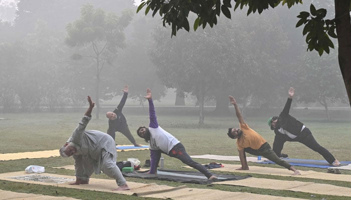 People exercise in a park amid heavy smoggy conditions in Lahore on November 7, 2024. — AFP