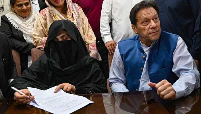 Former prime minister Imran Khan (right) along with his wife Bushra Bibi (centre) signs surety bonds for bail in various cases, at the registrars office in the Lahore High Court on July 17, 2023. — AFP