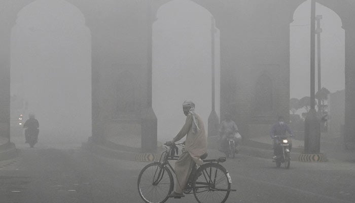 A man covers his face with a scarf to avoid smog as he walks along a road in Multan, Pakistan November 10, 2024. — AFP