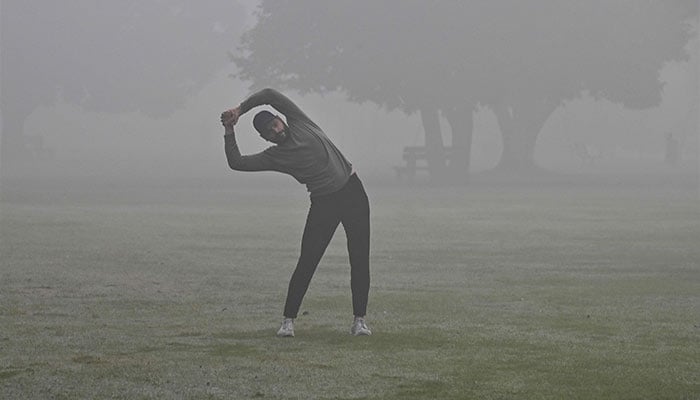 A man exercises in a park amid heavy smoggy conditions in Lahore on November 7, 2024. — AFP