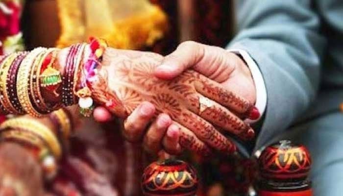 A representational image showing a groom and a bride holding hands. — AFP/File