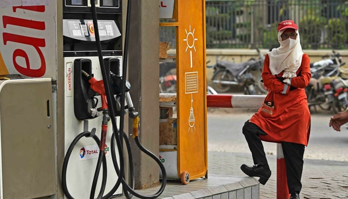 An employee waits for customers at a fuel station in Karachi on August 16, 2023. — AFP