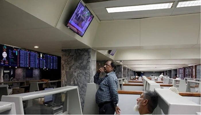 Stock brokers monitor new on television screen at a booth, during a trading session at the Pakistan Stock Exchange, in Karachi, on July 3, 2023. — Reuters