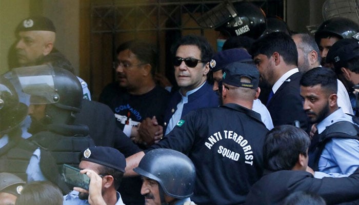 Security officers escort former prime minister and PTI founder Imran Khan, as he appeared in Islamabad High Court. — Reuters