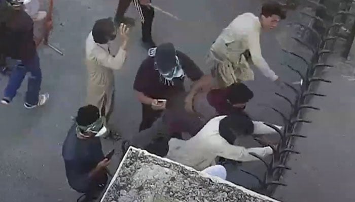 Purported PTI demonstrators trying to break gate of Pakistan Armys headquarters GHQ in Rawalpindi on May 9, 2023. — Screengrab via Geo News