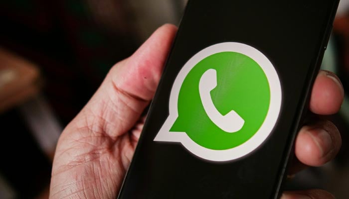 A representational image shows the WhatsApp logo displayed on a phone screen. — Unsplash