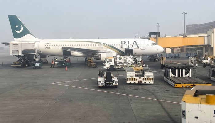 View of a Pakistan International Airlines (PIA) passenger plane, taken through a glass panel, at the Allama Iqbal International Airpor in Lahore. — Reuters/File