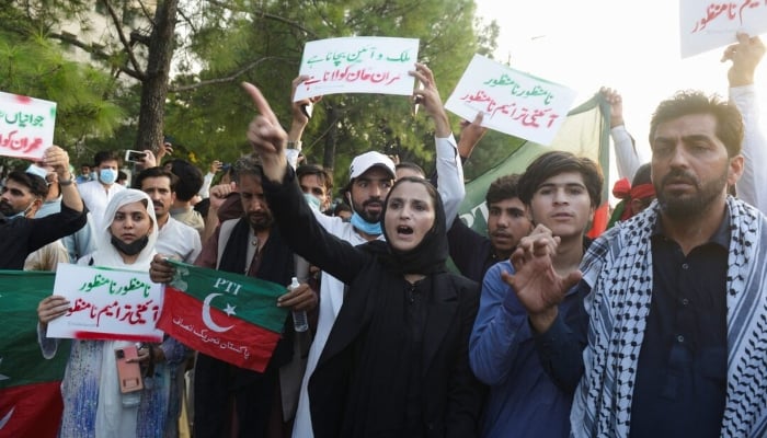 Supporters of the Pakistan Tehreek-e-Insaf (PTI) gather for an anti-government rally amid tear gas smoke fired by police to disperse them in Islamabad on October 4, 2024. —Reuters