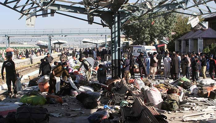 Police officers and people gather at the site amid the debris after a bomb blast at a railway station in Quetta on November 9, 2024. — Reuters