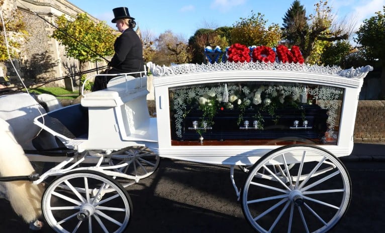 Liam Paynes casket arrived in a plain white horse-drawn carriage.