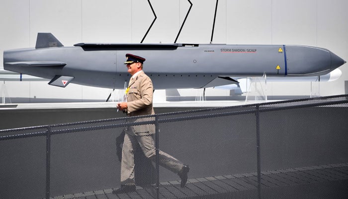 A member of the military walks past a MBDA Storm Shadow/Scalp missile at the Farnborough Airshow, south west of London, on July 17, 2018. — AFP