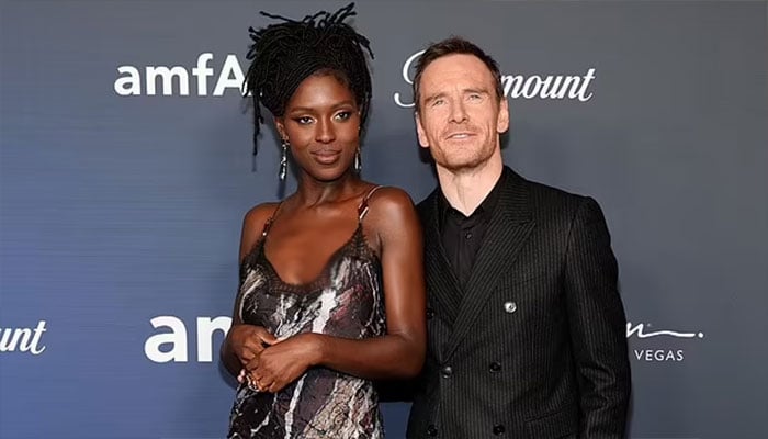 Jodie Turner-Smith and Michael Fassbender shine at the red carpet at amfAR event.