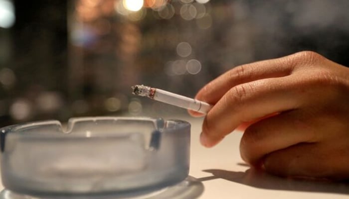 A customer smokes a cigarette in a cafe in Prague, Czech Republic. — Reuters/File